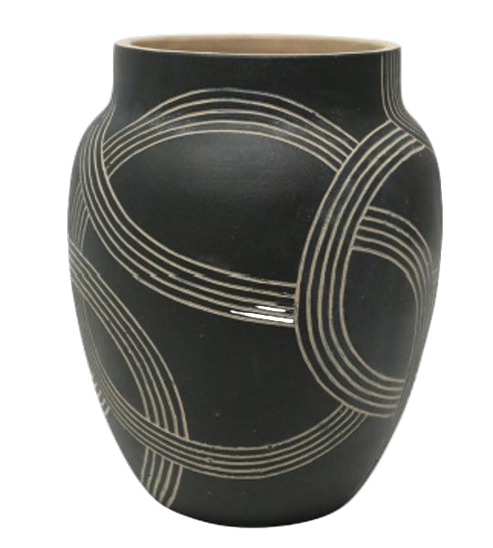 Black vase with white circular patterns on a white background